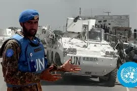 Peacekeeper standing in front of vehicle